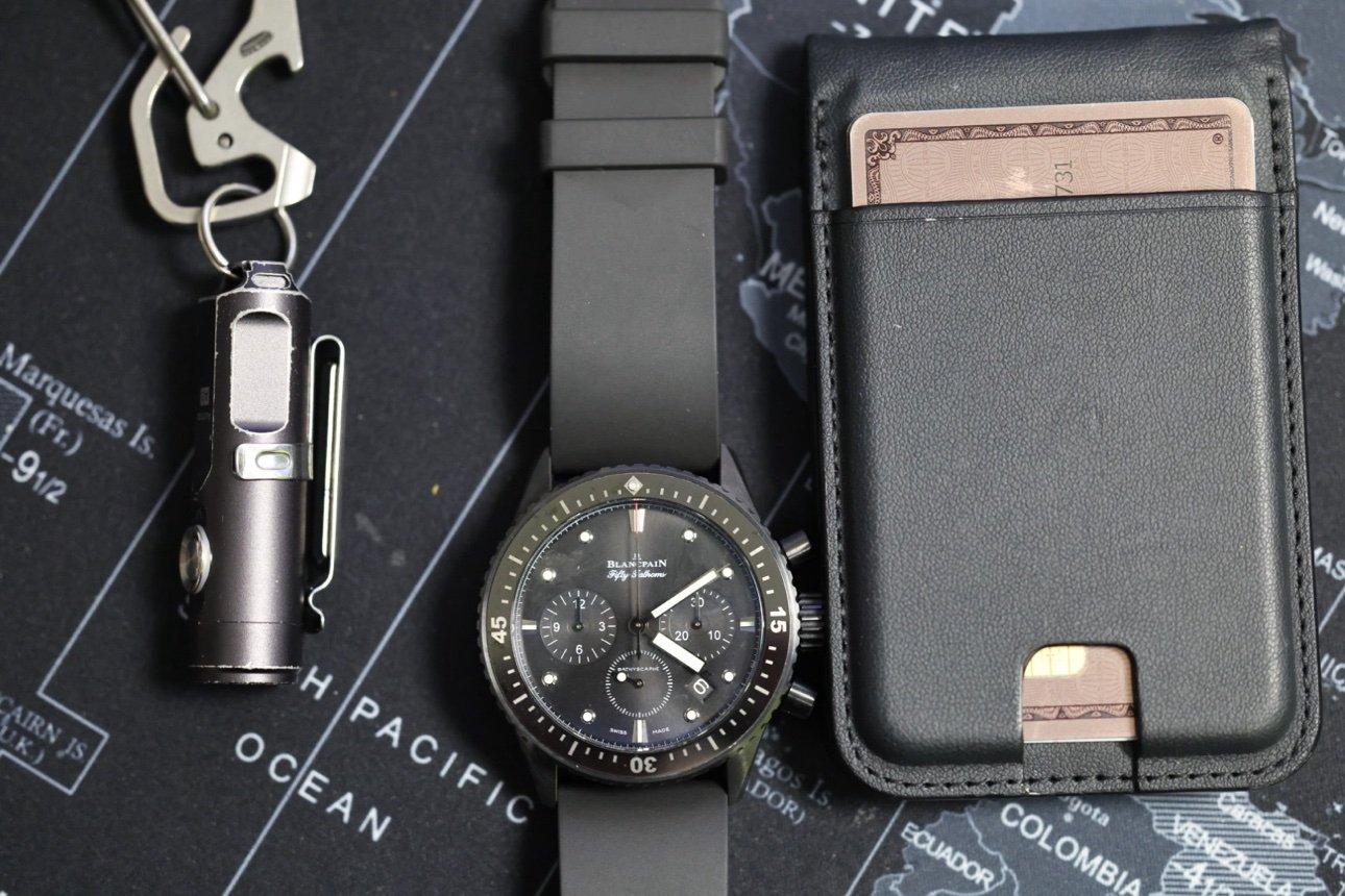 Watch flat lay with flashlight and card holder